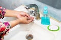 Women use liquid soap for rubbing and washing her hands under the water tap. Royalty Free Stock Photo