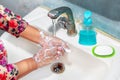 Women use liquid soap for rubbing and washing her hands under the water tap. Royalty Free Stock Photo