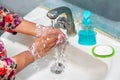 Women use liquid soap for rubbing and washing her hands under the water tap. Royalty Free Stock Photo