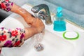 Women use liquid soap for rubbing and washing her hands under the water tap. Royalty Free Stock Photo