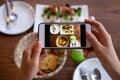 Women use mobile phones to take pictures of food or take live video on social networking applications. Food for dinner looks appet Royalty Free Stock Photo