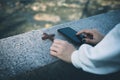 Women use smartphone on hand with a cross placed beside