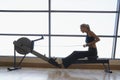 Women Using Rowing Machine In Health Club