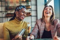 Women using tablet and credit card together inside cafe