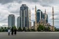 The women walk toward Grozny City skyscrapers and the Heart of Chechnya mosque in Grozny. Royalty Free Stock Photo