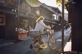 Women Walking Bicycle in an alley in a traditional Japanese Mountain Town in the Morning