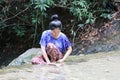 Women are washing the face behind the waterfall. Royalty Free Stock Photo