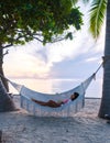 women watching sunrise in a White hammock under palm trees at a tropical beach in Thailand Hua Hin Royalty Free Stock Photo