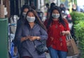 Women wear masks while walk on the street.