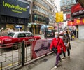 Women wear protective surgical face masks while walking along the street