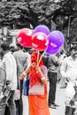 A women wear red saree selling a bunch of baloon