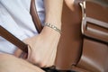 Women wear stainless steel bracelets and brown bag