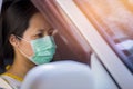 Women wearing surgical face mask driving a car, Covid-19 or Coronavirus concept