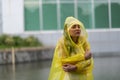 Women wearing yellow raincoat while raining in rainy season Royalty Free Stock Photo