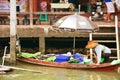 Women on wooden boats busy ferrying people at Amphawa floating m