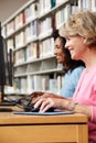 Women working on computers in library Royalty Free Stock Photo