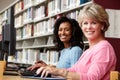 Women working on computers in library Royalty Free Stock Photo