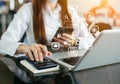 Women working on desk office with using a calculator to calculate and hand smartphone, finance accounting concept Royalty Free Stock Photo