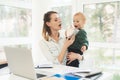 A woman works during maternity leave at home. A woman works and cares for a child at the same time. Royalty Free Stock Photo