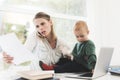 A woman works during maternity leave at home. A woman works and cares for a child at the same time. Royalty Free Stock Photo