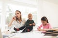 A woman works during maternity leave at home. A woman works and cares for a children at the same time. Royalty Free Stock Photo