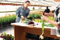 A woman wraps a bouquet of flowers in craft paper. Bouquet of purple tulips. Sale of bouquets from the greenhouse..