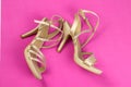 Women's beige sandals with rhinestones on high heels, on a pink background. Women's shoes. Lying sideways Royalty Free Stock Photo