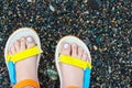 Women& x27;s feet in colorful sandals on the beach Royalty Free Stock Photo