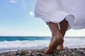 Women& x27;s feet in the sea. Close-up side view of a young woman& x27;s bare feet on a sandy sea beach at sunset. Royalty Free Stock Photo