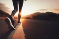 Women& x27;s feet in sneakers running on road web banner copy space. Young lady running on rural road