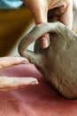 Women& x27;s hands knead the clay and sculpt a cup or bowl from it. The process of manufacturing a ceramic product,close