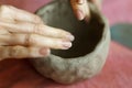 Women& x27;s hands knead the clay and sculpt a cup or bowl from it. The process of manufacturing a ceramic product,close
