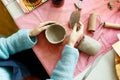 Women& x27;s hands knead the clay and sculpt a cup or bowl from it. The process of manufacturing a ceramic product,top