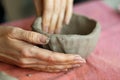 Women& x27;s hands knead the clay and sculpt a cup or bowl from it. The process of manufacturing a ceramic product,close