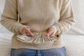 Women& x27;s hands in a white jumper hold money in their hands. Home on the couch. Royalty Free Stock Photo