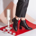 Women& x27;s legs in black pants and black short shoes on medium heel stands in the studio against a colored background Royalty Free Stock Photo