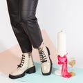 Women& x27;s legs in black pants and white short shoes on medium heel stands in the studio against a colored background Royalty Free Stock Photo