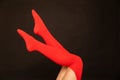 women& x27;s legs in red stockings on a black background Royalty Free Stock Photo