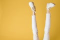 Women& x27;s legs Upside down white pants sneakers luxury water yellow background Royalty Free Stock Photo