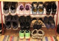 Womens, mens and childrens shoes are stored on an open shelf. Green Childrens Sneakers