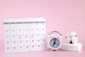 Women's menstrual pads, tampons, female menstruation calendar and alarm clock on a pink background. Royalty Free Stock Photo