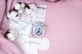 Women's menstrual pads, tampons, female menstruation calendar and alarm clock on a pink background. Royalty Free Stock Photo