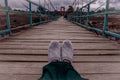 women& x27;s shoes. lonely woman. sad and broken hearted. woman sitting on the bridge.