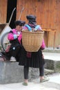 Women of the Red Yao hilltribes in traditional costume with wicker basket, Longsheng, China