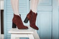 Womens brown suede fashion boots . slender female legs in white tights Royalty Free Stock Photo