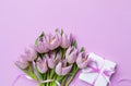 Womens day or mothers day greeting card. Gift box and heap of fresh beautiful tulip flowers on pastel lilac table Royalty Free Stock Photo