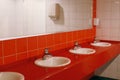 womens dressing room with red tiles on the wall, mirrors sinks for guests, toilet in the shopping center Royalty Free Stock Photo