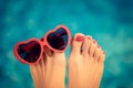 Womens feet with red pedicure against blue water background Royalty Free Stock Photo