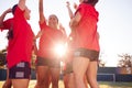 Womens Football Team Celebrating Winning Soccer Match On Outdoor Astro Turf Pitch