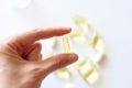 Womens hand is holding a pill. Tablets and pills laying on table.